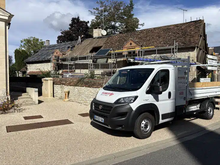Camion Robert B. Couvreur devant une maison en cours de rénovation, échafaudage monté le long de la toiture